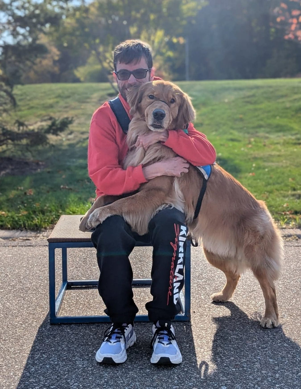 PuzzlePup founder Mike with his Helping Paws service dog Normie, a golden retriever in a service vest